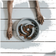 Die Pfoten eines Hundes ruhen auf einer weißen Holzoberfläche neben einer grauen langsamen Futterstation, die mit Trockenfutter gefüllt ist.