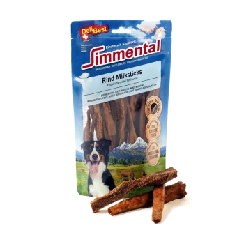 Eine Tüte DeliBest Simmental Rindfleisch-Milchsticks für Hunde, mit einem schwarz-weißen Hund auf der Vorderseite, mit drei Sticks davor.