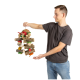 Eine Person hält ein buntes Holzspielzeug für Vögel, das aus verschiedenen Stämmen und bemalten Teilen besteht und für die Bereicherung von Haustieren entworfen wurde.