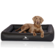 Ein brauner Hund, der auf einem schwarzen, gesteppten Hundebett liegt, mit dem Logo "KNUFFELWUFFF", das prominent auf der Vorderseite angezeigt wird.
