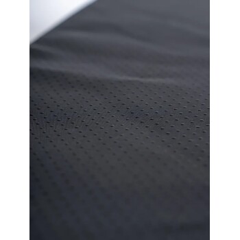 Nahaufnahme von schwarzem, strukturiertem Haustierbettstoff mit kleinen erhabenen Punkten für besseren Halt.