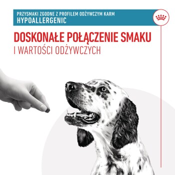 Ręka trzyma smakołyk dla psa nad szczęśliwym, cętkowanym psem. Tekst brzmi "Doskonałe połączenie smaku i wartości odżywczych" oraz "Hipoalergiczne."