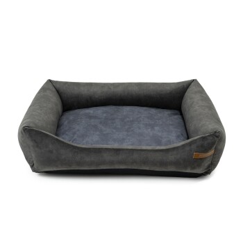 Graues Haustierbett mit einer weichen, plüschigen Oberfläche und erhöhten Seiten, mit einem dunkelblauen Innenraum und einem kleinen Lederetikett.