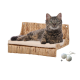 Eine entspannte getigerte Katze liegt auf einem geflochtenen Katzenbett mit einem beigen Kissen, begleitet von zwei kleinen Spielbällen.