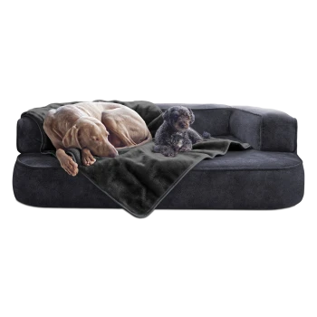 Ein großer grauer Hund und ein kleiner schwarzer Hund ruhen sich auf einem plüschigen, dunkelgrauen Hundesofa aus, das mit einer weichen Decke bedeckt ist.