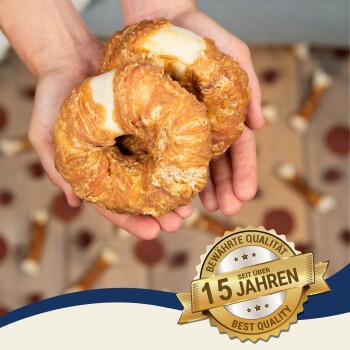 Zwei hundeförmige Leckerlis mit cremiger Füllung, die in Händen gehalten werden, mit einem "15 Jahre"-Abzeichen für 15 Jahre Qualität.