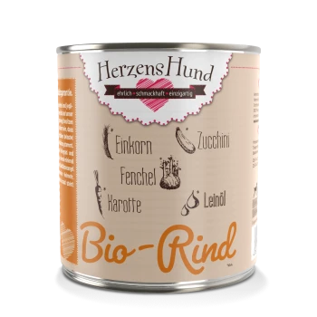 Een blik hondenvoer gelabeld 'HerzensHund Bio-Rind,' met illustraties van ingrediënten zoals einkorn, courgette, venkel, wortel en lijnzaadolie.
