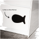 Schwarze, fischförmige Silikon-Saugplatte, die an einer weißen Oberfläche haftet, mit dem Text 'haftet an Oberflächen', der anzeigt, dass sie an Oberflächen haftet.