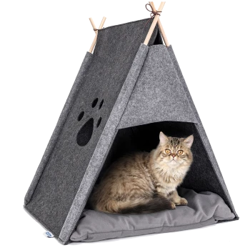 Eine flauschige Katze sitzt in einem grauen Filz-Teepee-Hundebett mit einem Pfotenabdruck-Ausschnitt und ruht sich auf einem weichen grauen Kissen aus.