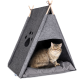 Eine flauschige Katze sitzt in einem grauen Filz-Teepee-Hundebett mit einem Pfotenabdruck-Ausschnitt und ruht sich auf einem weichen grauen Kissen aus.