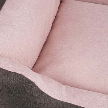 Eine Nahaufnahme eines Hundebettes mit einem weichen rosa Innenfutter und einem dunkelgrauen Außenmaterial, das sein gemütliches Design zeigt.