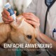 Ein Tierarzt, der eine Ohrreinigungslösung ins Ohr eines Hundes aufträgt, mit dem Text 'EINFACHE ANWENDUNG' und 'Zur Reinigung des äußeren Gehörgangs' sichtbar.