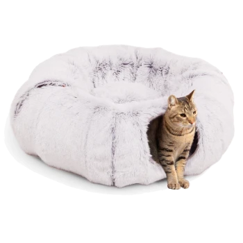 Ein gemütliches, rundes, hellgraues Katzenbett mit flauschiger Textur, mit einer getigerten Katze, die am Eingang sitzt.