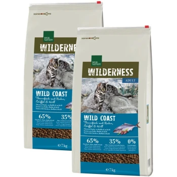 Zwei 7 kg Säcke Real Nature Wilderness Wild Coast Katzenfutter mit einer getigerten Katze auf einem felsigen Hintergrund, mit 65% Fleischanteilen.