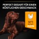 Nahaufnahme eines braunen Hundes, der nach oben schaut, mit dem Text "PERFEKT GEGART FÜR EINEN KÖSTLICHEN GESCHMACK" und einem orangefarbenen "N°1 ZUTAT HUHN"-Label.