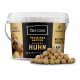 Behälter mit Chewies Hundetraining Leckerlis, mit einem Hundebild, beschriftet mit "Chicken Huhn", getreidefrei, mit verstreuten Leckerlis davor.