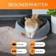 Eine flauschige orangefarbene Katze entspannt sich in einem grauen Haustierbett auf einem rosa Teppich, mit Merkmalen: "Kuschlig", "Atmungsaktiv", "Modern", "Hoher Rand."