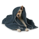 Ein gemütlicher Hund, eingewickelt in eine dunkelgraue Decke mit weißen Nähten, schaut neugierig in die Kamera.