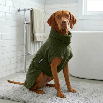 Ein weicher, olivgrüner Hundemantel mit einem runden Kragen und einer kleinen Tasche mit dem Etikett "THE DOG IDEA."