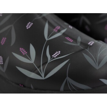 Nahaufnahme eines schwarzen Haustierstiefels mit floralem Muster, das graue Blätter und rosa Blumen zeigt.