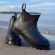 Schwarze wasserdichte Knöchelstiefel mit Profilsohlen und Wassertropfen am Strand; Etikett lautet 'Gateway Jo'
