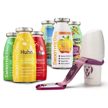 Eine Sammlung von bunten Hundesmoothie-Flaschen, beschriftet mit "SmoothieDog" mit Geschmacksrichtungen wie Huhn und Immuno, neben einem rosa Haustierzubehör.