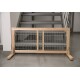 Holztiergitter mit Metallstäben, am Fuß einer Treppe platziert, mit einem einfachen Design und robuster Konstruktion.