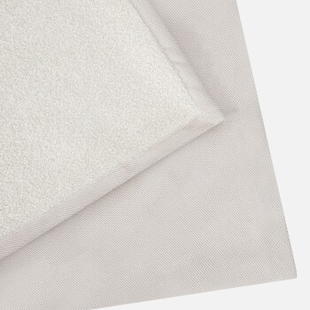 Zwei geschichtete Tiermatten: eine weiche beige und flauschige, die andere glatt und in einem etwas dunkleren Farbton gewebt.