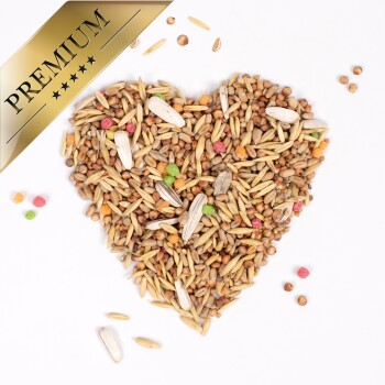 Herzförmige Anordnung verschiedener Samen und Körner mit bunten Pellets, gekrönt von einem goldenen "PREMIUM"-Banner.