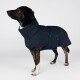 Ein stilvoller Hund trägt einen dunkelblauen Fleece-Mantel mit hohem Kragen, der eine Seitentasche und ein Etikett mit der Aufschrift "THE DOG GIG" zeigt.