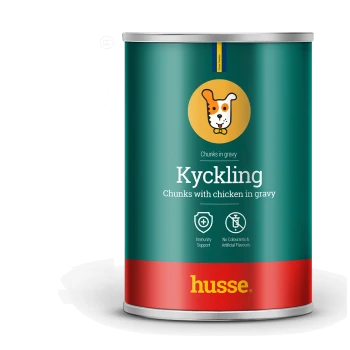 Dose Husse Kyckling Hundefutter, mit der Aufschrift "Stücke mit Hähnchen in Soße," mit Immunitätsunterstützung und ohne künstliche Aromen.