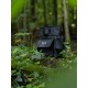 Eine schwarze Leckerli-Tasche für Haustiere mit Klappe, die das Logo "TwinTreat" in Weiß zeigt, liegt auf einem moosigen Baumstamm, umgeben von Grün in einer Waldumgebung.
