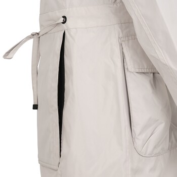 Eine Nahaufnahme einer hellbeigen Haustierjacke mit Kordelzug in der Taille, Seitentaschen und einem glatten, wasserabweisenden Stoff.