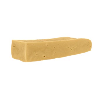 Ein rechteckiges Stück hellbraunes Tierkauzeug, das Käse ähnelt, mit einer glatten Oberfläche und kleinen Luftblasen.