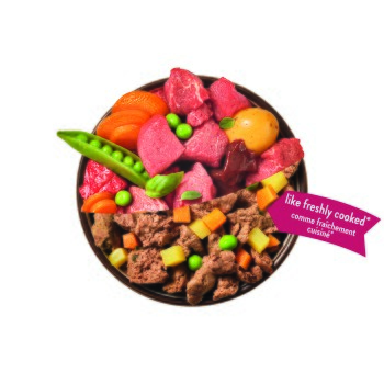 Schüssel mit Haustierfutter mit rohen und gekochten Fleischstücken, Erbsen, Karotten, Kartoffel; pinker Anhänger mit der Aufschrift 'wie frisch gekocht*'.
