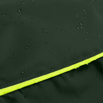 Nahaufnahme einer dunkelgrünen wasserdichten Haustierjacke mit Wassertropfen auf der Oberfläche und einem leuchtend gelben reflektierenden Streifen.
