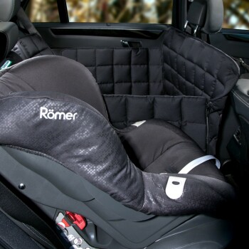 Ein schwarzer Römer-Autositz mit einem gepolsterten Seitenprotektor ist in einem Fahrzeug positioniert und zeigt seine Sicherheitsmerkmale und das Komfortdesign.