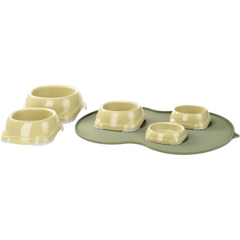 Set aus vier Futter- und Wassernäpfen für Haustiere in sanftem Gelb, auf einer grünen Matte mit rutschfesten Kanten angeordnet.