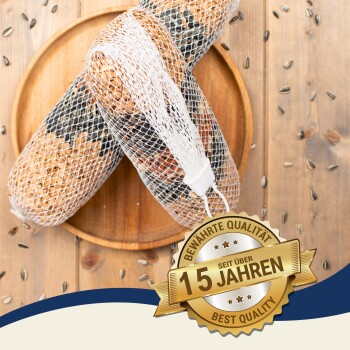 Zwei zylindrische Vogelhäuser in weißem Netz auf einem Holzbrett mit Sonnenblumenkernen, mit einem goldenen Qualitätssiegel.