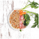 Eine geteilte Schüssel mit körnigem Haustierfutter und Gemüse auf einer Seite und rohem Hähnchen, Brokkoli und Karotten auf der anderen.