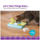 Eine Bengal-Katze schnüffelt an einer bunten langsamen Futter-Schüssel mit dem Text: "Lass uns die Dinge langsam angehen..." und "Verwenden bei Leckereien oder zur Mahlzeit."