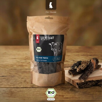 Brauner Kraftpapierbeutel mit Liebesgut Bio‑Rind Pansen Hundesnacks, Kuhgrafik, BIO‑Logo und getrocknetem Pansen auf einem Holzbrett