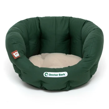 Grünes Haustierbett mit einem plüschigen beigen Zentrum, das das Logo "Doctor Bark" auf der Vorderseite zeigt.