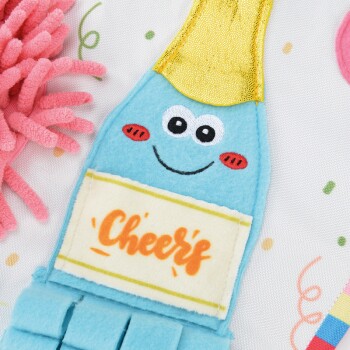 Un jouet pour animaux de compagnie bleu mignon en forme de pinceau avec un visage souriant et un dessus doré, présentant le texte "Cheers" sur une étiquette blanche.