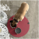 Ein Hund frisst aus einer weißen Schüssel, die mit Trockenfutter gefüllt ist, auf einem runden rosa Teppich. Zwei weitere Schüsseln, eine graue und eine leere, sind in der Nähe.