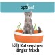Eine graue Katze sitzt in einer orangefarbenen Katzentoilette mit grünen Wirbeln darüber, die Frische fördert. Der Text lautet "hält Katzenstreu länger frisch."