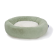 Ronde huisdierbed in zacht groene stof met een pluche witte binnenkant, ontworpen voor comfort en ontspanning.