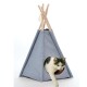 Eine grau-weiße Katze, die aus einem blauen Stoff-Teepee-Haustierzelt mit Holzpfosten herauskommt, mit einem runden Eingang.