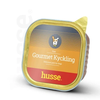 Paté für Hunde in einem quadratischen goldenen und orangefarbenen Behälter, beschriftet mit "Gourmet Kyckling" von Husse, mit einem Hundesymbol und dem Text "Delicious paté for dogs."
