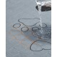 Grau gestepptes, wasserdichtes Haustierkissen mit aufgenähten Pfotenkonturen und orangefarbener Naht; Wasser wird darauf gegossen und perlt auf der Oberfläche ab